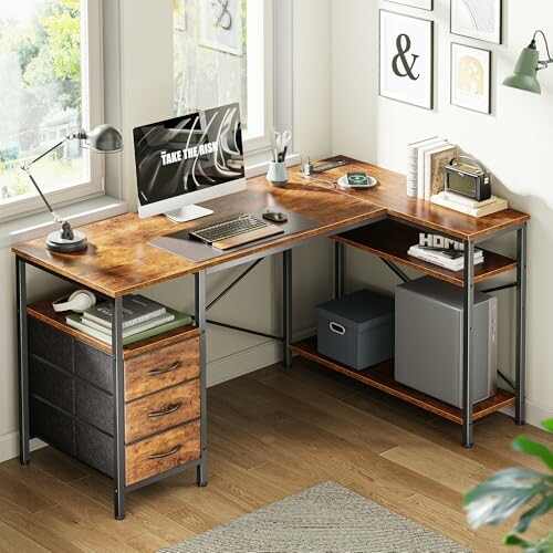 L-shaped wooden desk with computer, lamp, books, and storage in a home office.