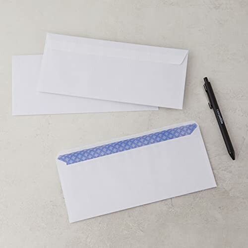 Two white envelopes and a black pen on a table.